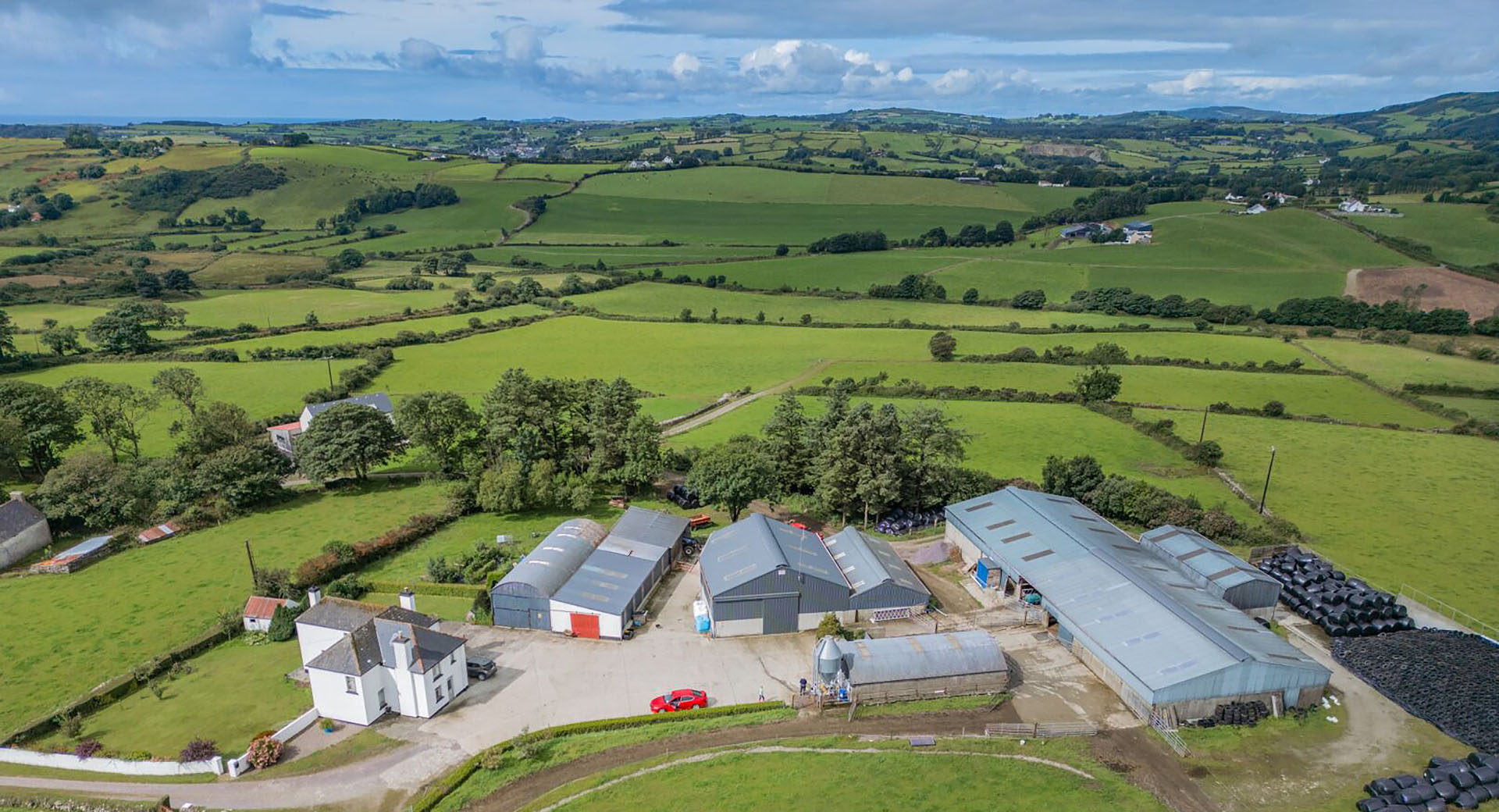 Drone shot of farm sheds with fields in background